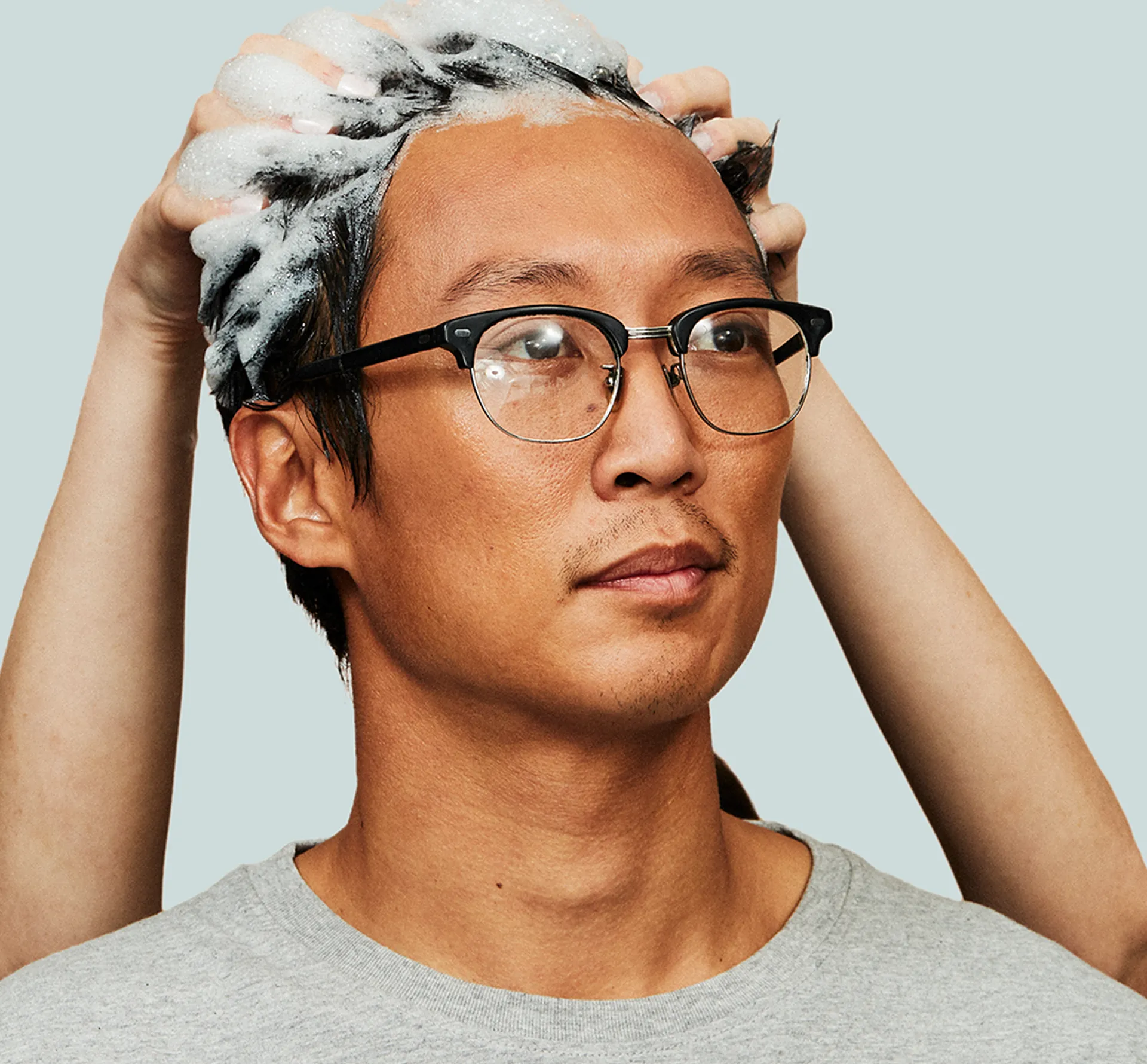 Hims shampoo being massaged into a man's hair