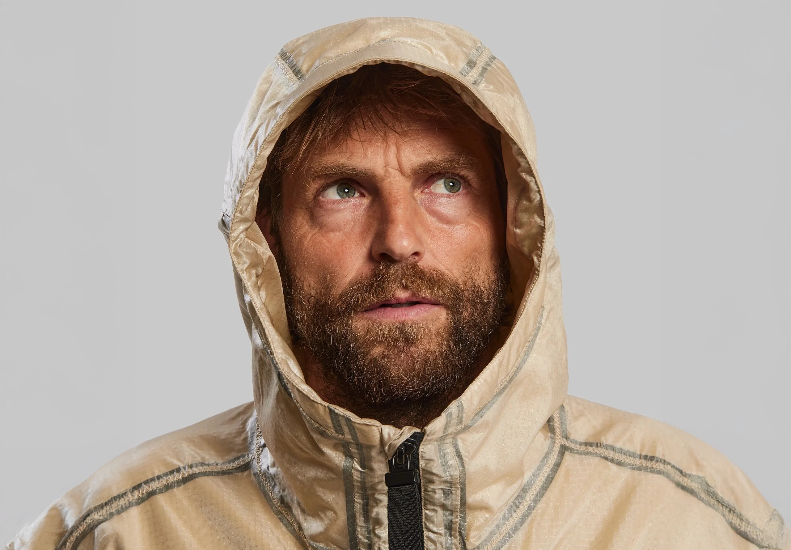 Man in a hooded jacket looking up