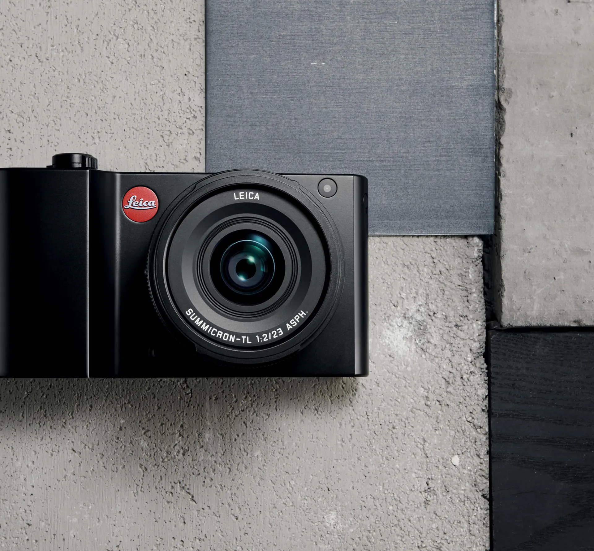 Black Leica camera on a concrete tile background